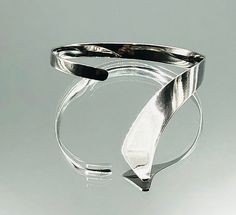 *About me: 925 silver cuff bangle. I think I am a stylish modernist twist on the torque wristband with a feature that flows over the hand. *Size: Approx. length 21cm /8.26 inches , inner length 18cm / 7 inches including gap, width 1.3cm / 0.51 inches at widest graduating to 0.5cm /0.19 inches, gap 3cm / 1.18 inches flexible *Weight: Approx. 17.8 grams *Hallmark: 925 *Age: Vintage *Condition: Good vintage condition *Gift boxed to your door ** A vintage item that has been pre-loved, history of wea Modern Sterling Silver Bracelet, Modern Adjustable Bangle With Polished Finish, Modern Twist Cuff Bracelet For Formal Occasions, Modern Cuff Bangle Bracelet, Modern Adjustable Sterling Silver Bracelet With Polished Finish, Adjustable Modern Sterling Silver Bracelet With Polished Finish, Modern Twist Polished Bangle Cuff Bracelet, Modern Sterling Silver Bangle Bracelet For Formal, Modern Sterling Silver Bangle