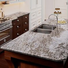 a kitchen with an oven, sink and counter top in it's center island