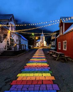 an image of a street that has been painted with rainbow colors and string lights on it