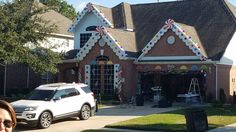 a white car is parked in front of a house with candy canes on the roof