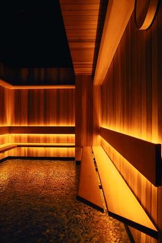 a dimly lit room with wooden walls and benches