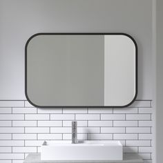 a white sink sitting under a bathroom mirror next to a wall mounted faucet