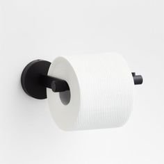 a black and white toilet paper holder on a wall with a roll of toilet paper