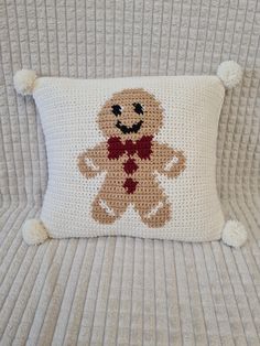 a crocheted teddy bear pillow on a bed