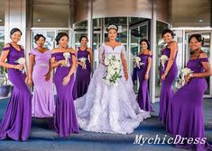 a group of women standing next to each other in front of a glass door wearing purple dresses