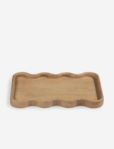 a wooden tray with wavy edges on a white background, it is made out of wood