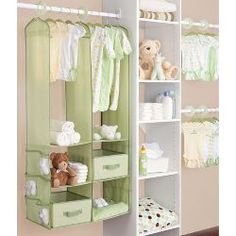 a baby's closet with clothes and teddy bears on the shelves in front of it