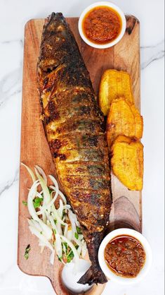 the fish is prepared and ready to be served with sauces on the side, along with other foods