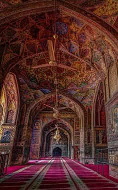 the inside of an ornate building with red carpet and intricate paintings on it's walls