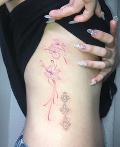 a woman's stomach with pink flowers on it and her hand touching the side