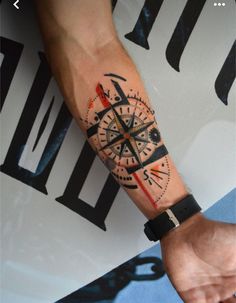 a man with a compass tattoo on his arm