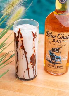 a bottle of blue chaul bay spiced rum next to a shot glass filled with ice