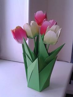 an origami flower vase with pink and white tulips