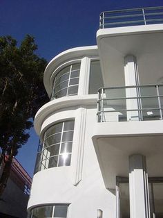 a tall white building with balconies and windows