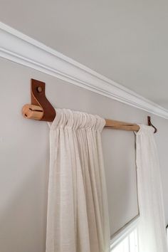 the curtain is pulled back from the wall by a wooden hook on it's side