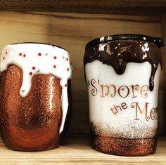 two coffee mugs sitting on top of a wooden shelf next to eachother