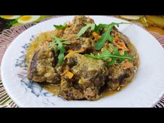 a white plate topped with meat covered in gravy