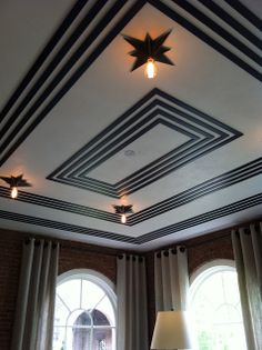 a living room filled with lots of windows and furniture under a star shaped light fixture