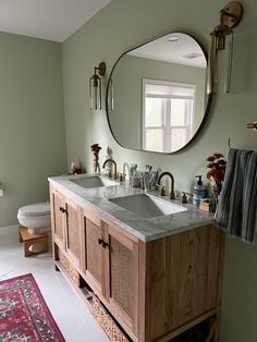 a bathroom with two sinks and a large round mirror above the sink in front of it