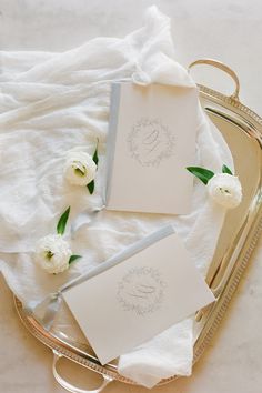 wedding stationery with white flowers and monogrammed napkins on a silver tray