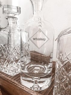 glass bottles and decanters are sitting on a wooden tray