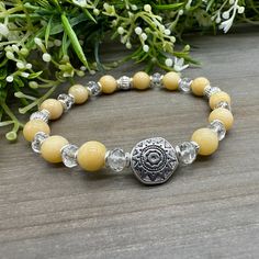 This 7.25 inch bracelet is created with 8 mm genuine Yellow Jade stones combined with faceted rondelle Clear Quartz beads, and a pretty silver tone sun motif focal accent.  It stretches for a comfortable fit and only high-quality natural stones are used in every handmade design. Yellow Jade: a stone of wisdom and self-confidence; provide support, guiding light, and  encouragement Clear Quartz: provides healing, clarity, and energy amplification Yellow Crystal Bracelets, Sun Motif, Yellow Jade, Hippie Bracelets, Guiding Light, Beaded Necklace Diy, Crystal Healing Stones, Necklace Diy, Crafts Jewelry