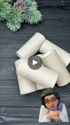 an animated image of a woman sitting in front of two rolls of toilet paper on a table