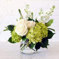 a vase filled with white and green flowers