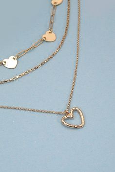 Introducing our Multi-Layer Mini Hearts Charm Necklace, a whimsical and delightful accessory designed to bring a touch of romance and playfulness to your jewelry collection. The necklace features multiple layers adorned with charming mini heart-shaped pendants. The multi-layered style adds depth and dimension to the necklace. DIMENSIONlength: 20", 18", 16"charm size: .65", .45" heartext: 3" Ball Chain Extclasp: Lobster Clawmetal finish: Gold Platedproduct: Lead & Nickel Compliantanti-tarnish: Do Layered Chain Necklace, Steel Necklace, Sunglass Chain, Layered Chains, Square Pendant, Mini Heart, Accessories Necklace, Ball Chain, Multi Layering