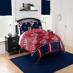 a baseball themed bed in a bedroom with blue and red accessories on the bedding