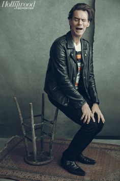 a man sitting on top of a wooden chair