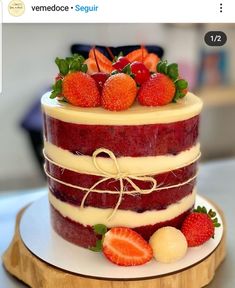 a three layer cake with strawberries on top