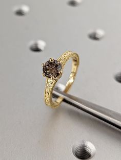 a gold ring with a brown diamond on it