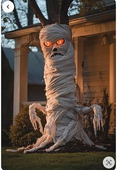 a creepy looking tree with red eyes in front of a house