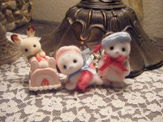 three small figurines sitting on top of a table next to a lamp shade