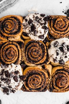 several different types of pastries are arranged on a white surface with chocolate chips and sprinkles