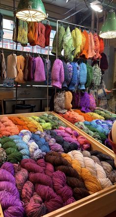 there are many skeins of yarn on display in the market place for sale