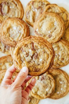 a hand holding up a chocolate chip cookie