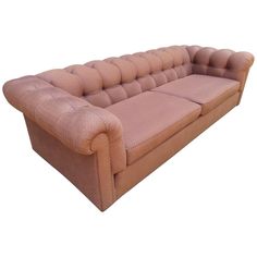 a pink couch sitting on top of a white floor