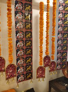 the wall is decorated with orange flowers and decorative items hanging from it's sides