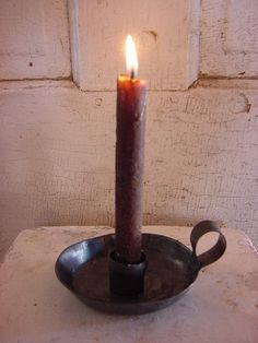 a lit candle sitting on top of a metal tray