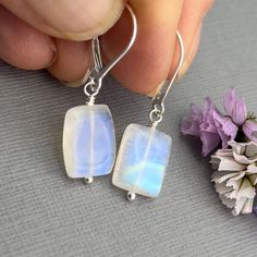 ✦These beautifully polished high quality rainbow moonstones rectangles have the gorgeous flashes of blue, turquoise and green opalescence.  The stones are rectangular shaped, center drilled and measure about 1/2 inch by 3/8. They and wire wrapped with sterling silver head pins and hang from all sterling silver ear wires. ✦Earring length is about 1.25 inches. Available with your choice of sterling silver lever back or French hook ear wires. Please select ear wire style at check out. ✦Your jewelry will be packaged in a beautiful and reusable organza bag. All items will be placed in the same organza bag. If you need a separate bag for each item, please leave a comment at check out. ✦To receive your item in a gift box with a colorful ribbon, please purchase the gift wrapping option at check ou Colorful Ribbon, June Birthday, June Birthstone, Head Pins, June Birth Stone, Moon Stone, Blue Turquoise, Organza Bags, Ear Wire