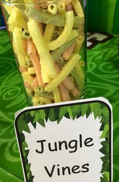 a glass filled with food sitting on top of a table next to a sign that says jungle vines