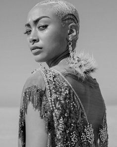 a black and white photo of a woman with shaved hair