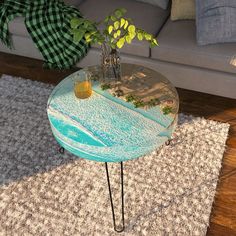 a coffee table with a glass top and metal hairpin legs on a rug in front of a couch