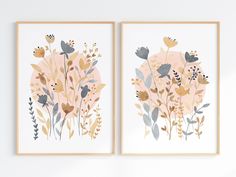 two framed art prints with flowers and birds on them, one in gold and the other in grey