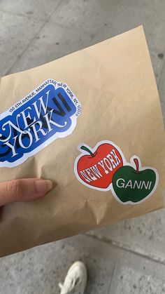 a person holding a brown bag with stickers on it