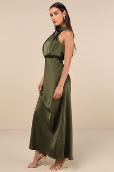 The Lulus Distinctive Charm Olive Green Satin Asymmetrical Maxi Dress is ready to party with the best (and most stylish) of them! Ultra-sleek woven satin shapes this chic dress that has a trendy mock neckline and a blousy, asymmetrical bodice with gathering. The fitted waist tops a figure-skimming, A-line maxi skirt. Top button closures secure atop a keyhole-style cutout at the back. Hidden back zipper/clasp. Fit: This garment fits true to size. Length: Floor length. Size medium measures 60.5" from shoulder to hem. Bust: Great for any cup size. Waist: Fitted - very fitted at natural waist. Hip: Loosely Fitted. Undergarments: May be worn with a strapless bra, adhesive bra, petals, or no bra. Fabric: Fabric has no stretch. Lined. Shell: 100% Polyester. Lining: 97% Polyester, 3% Spandex. Hand Satin Floor Length Dress, Olive Green Dress Outfit Wedding, Army Green Dresses, Olive Green Dress Outfit, Green Dress Outfit, Long Dresses For Women, Asymmetrical Maxi Dress, Army Green Dress, Sleek Chic