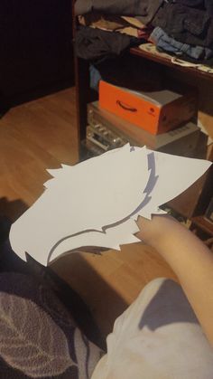 someone is cutting out a paper bird on the floor