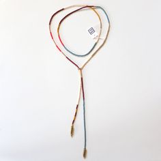 a multicolored beaded necklace on a white background with a tag in the middle